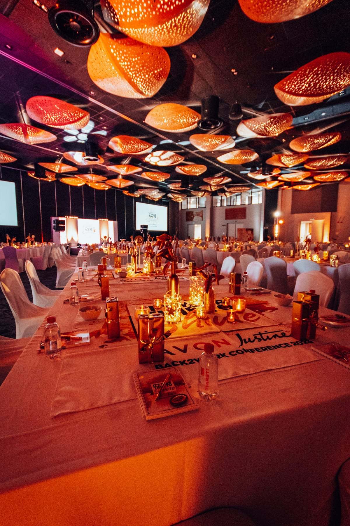 Tables lit warm orange under the ballroom's feature ceiling