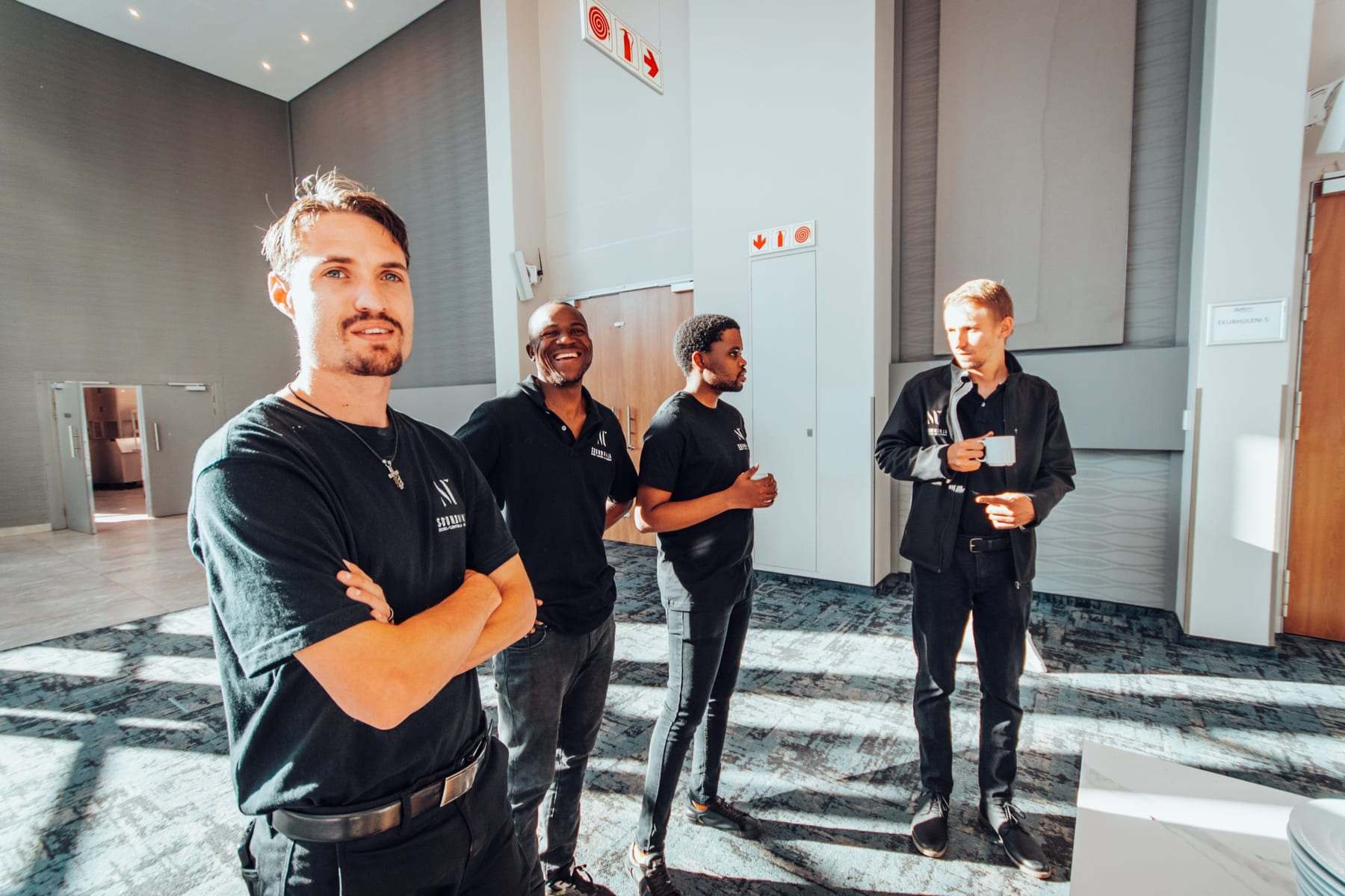Four Sound Ninja crew members in branded shirts and jackets before the doors open