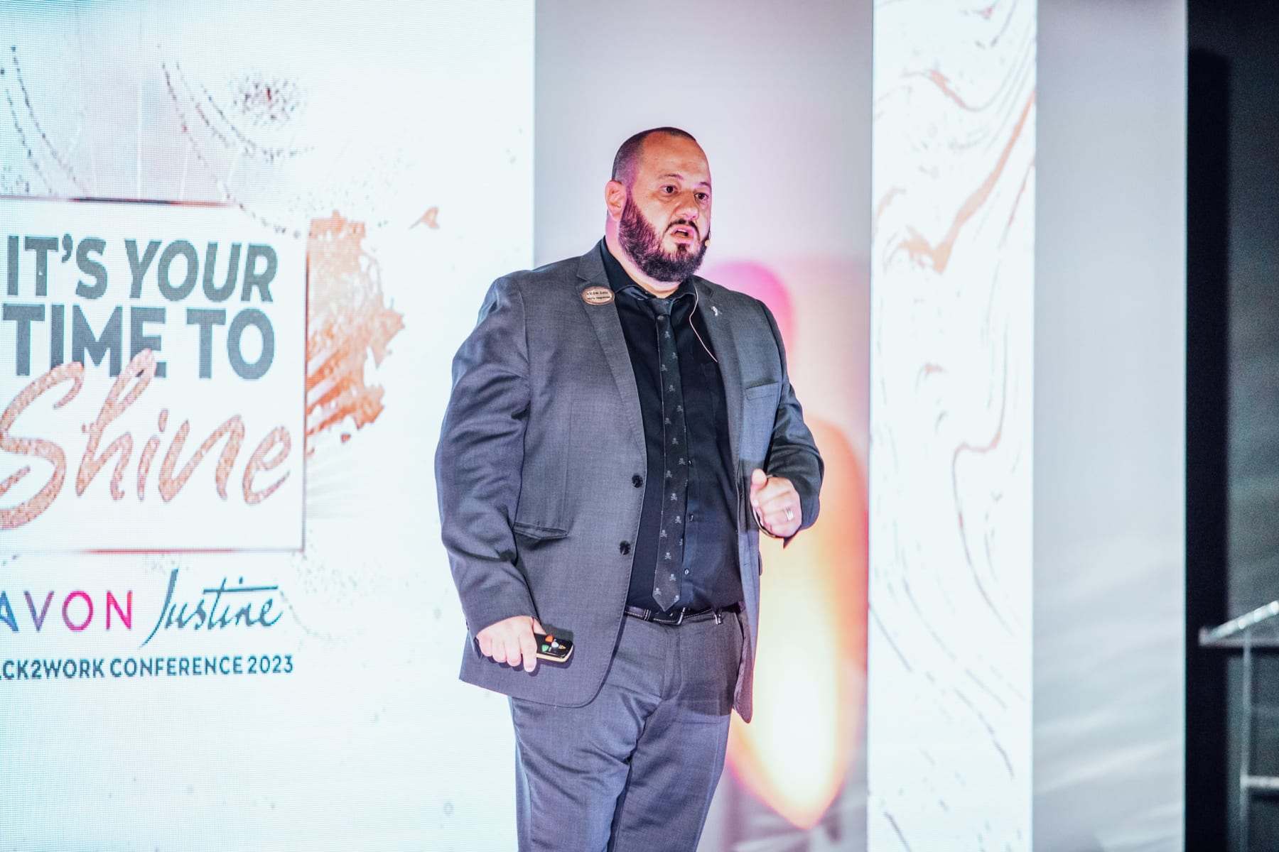 A speaker on stage in front of the It's your time to shine backdrop