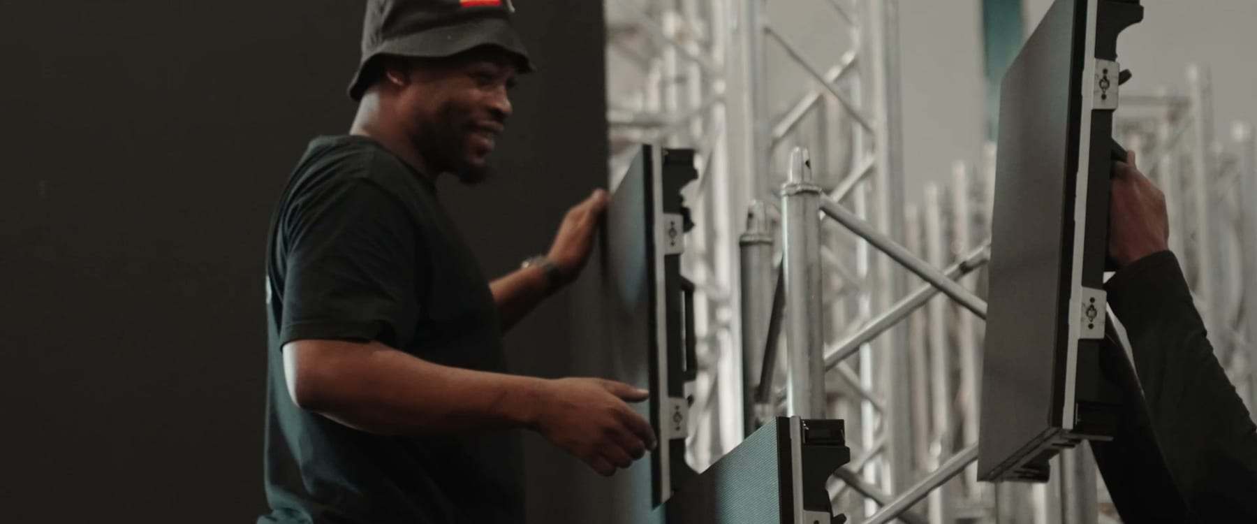 A crew member hanging LED panels on the truss before the show