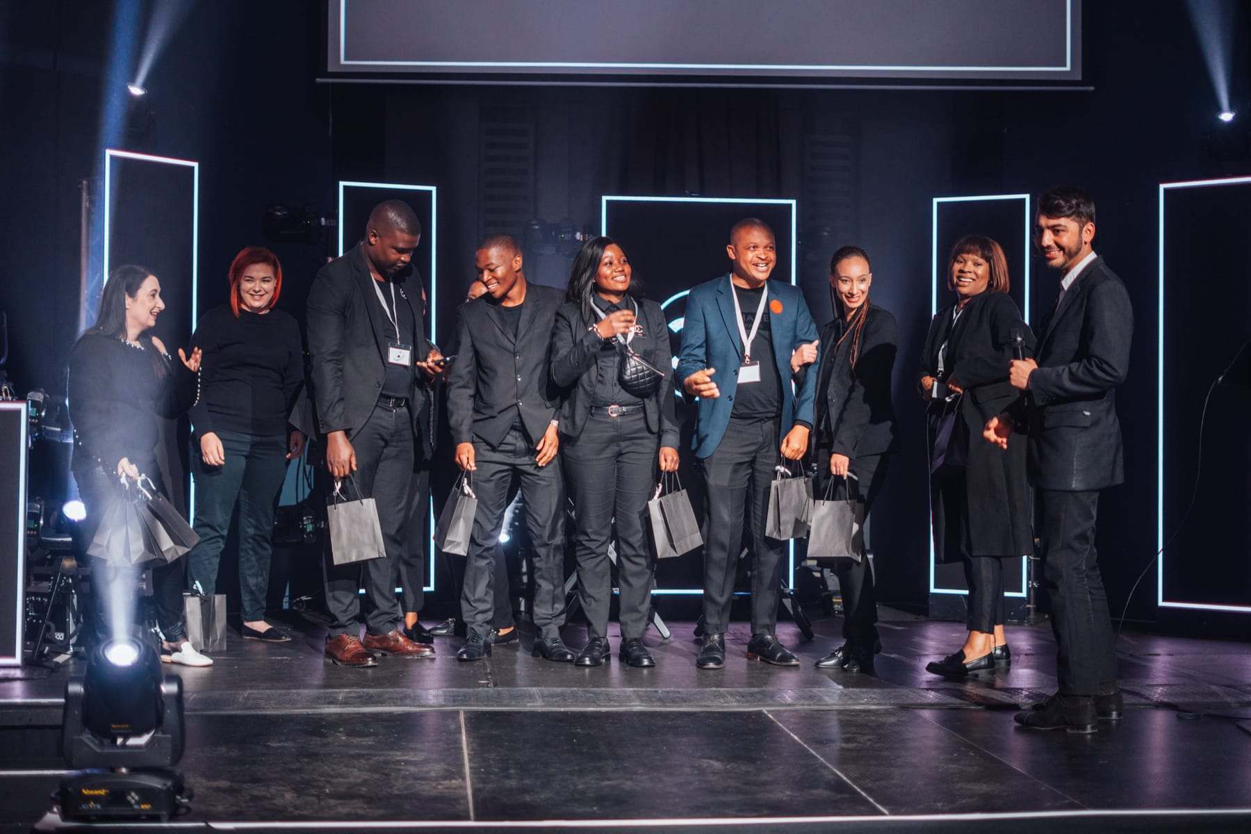 The team on stage between the light frames at the end of the night