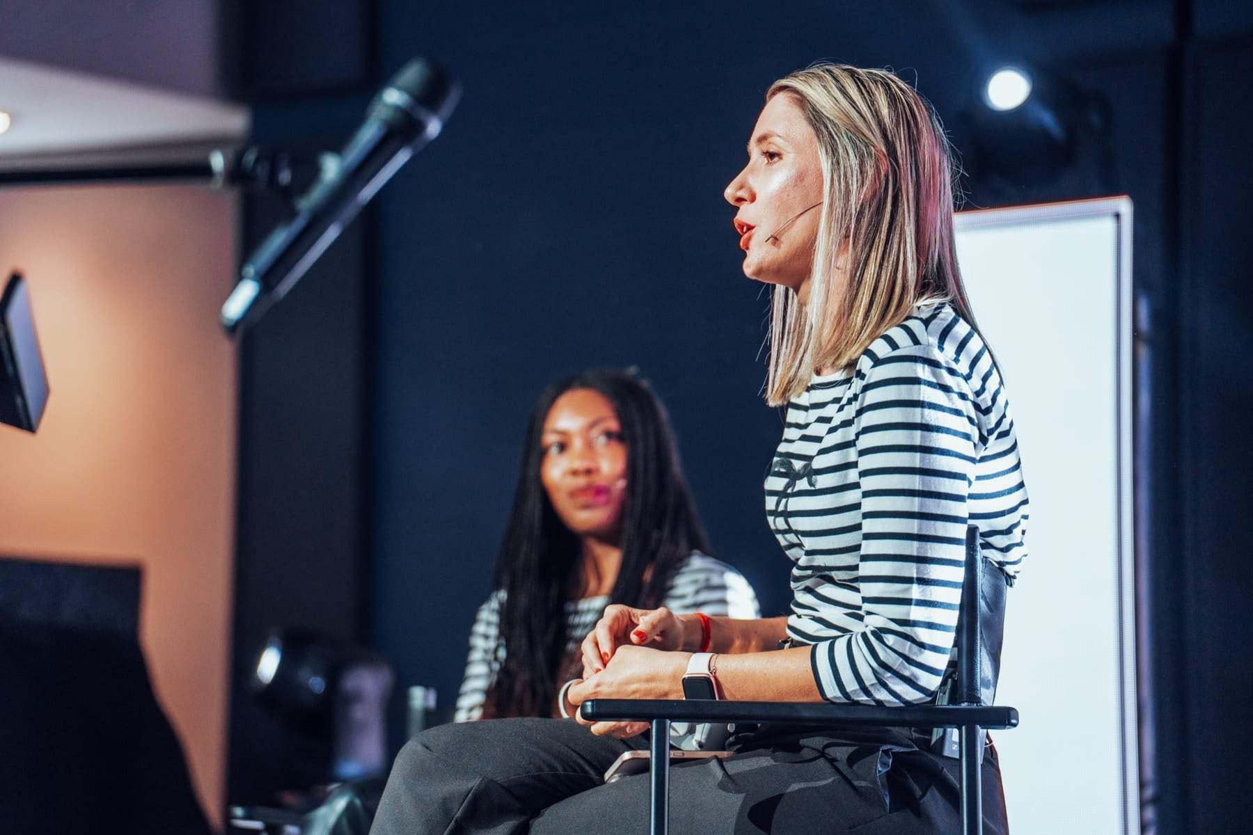 A seated interview on stage with a microphone
