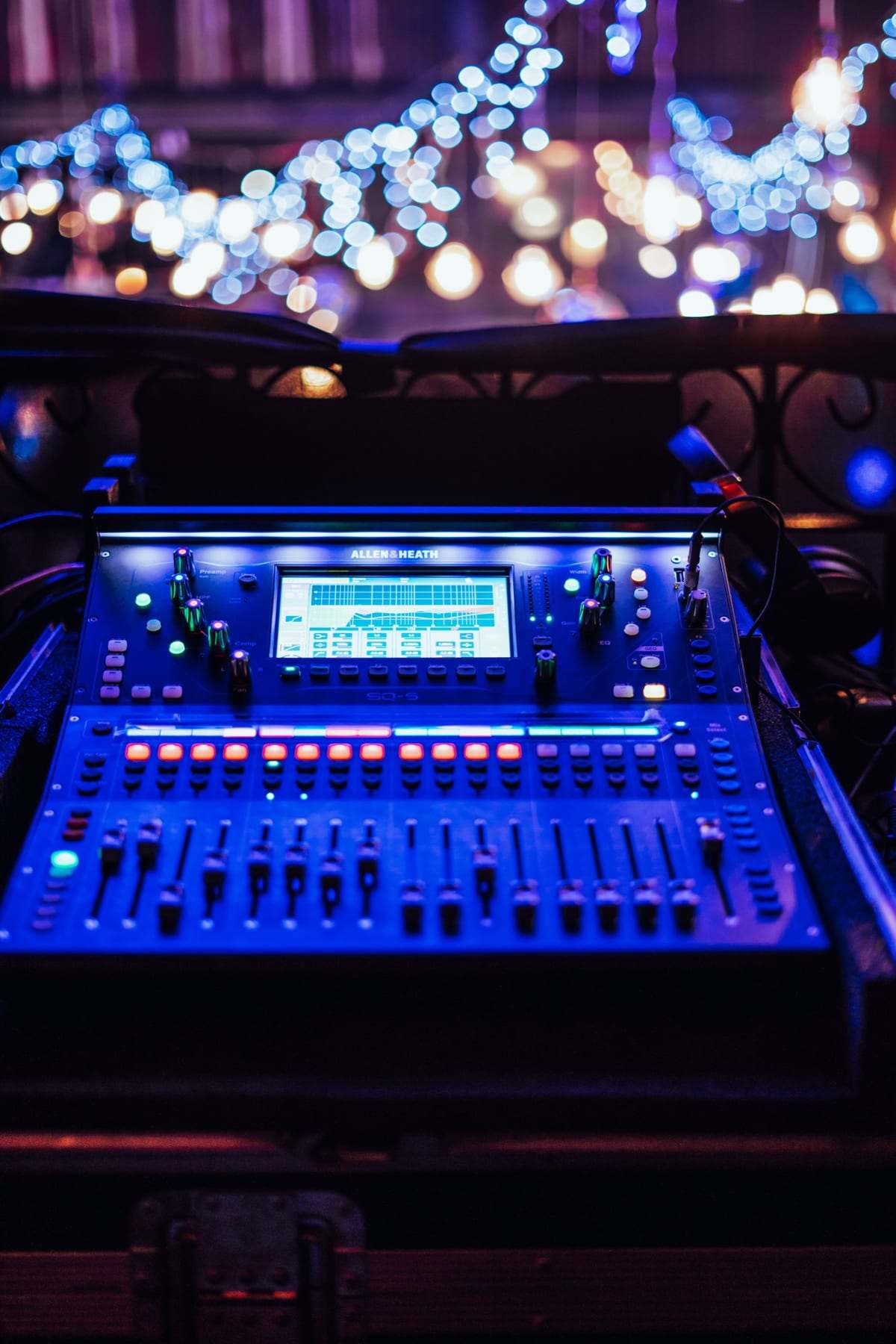 A digital mixing desk lit blue at front of house