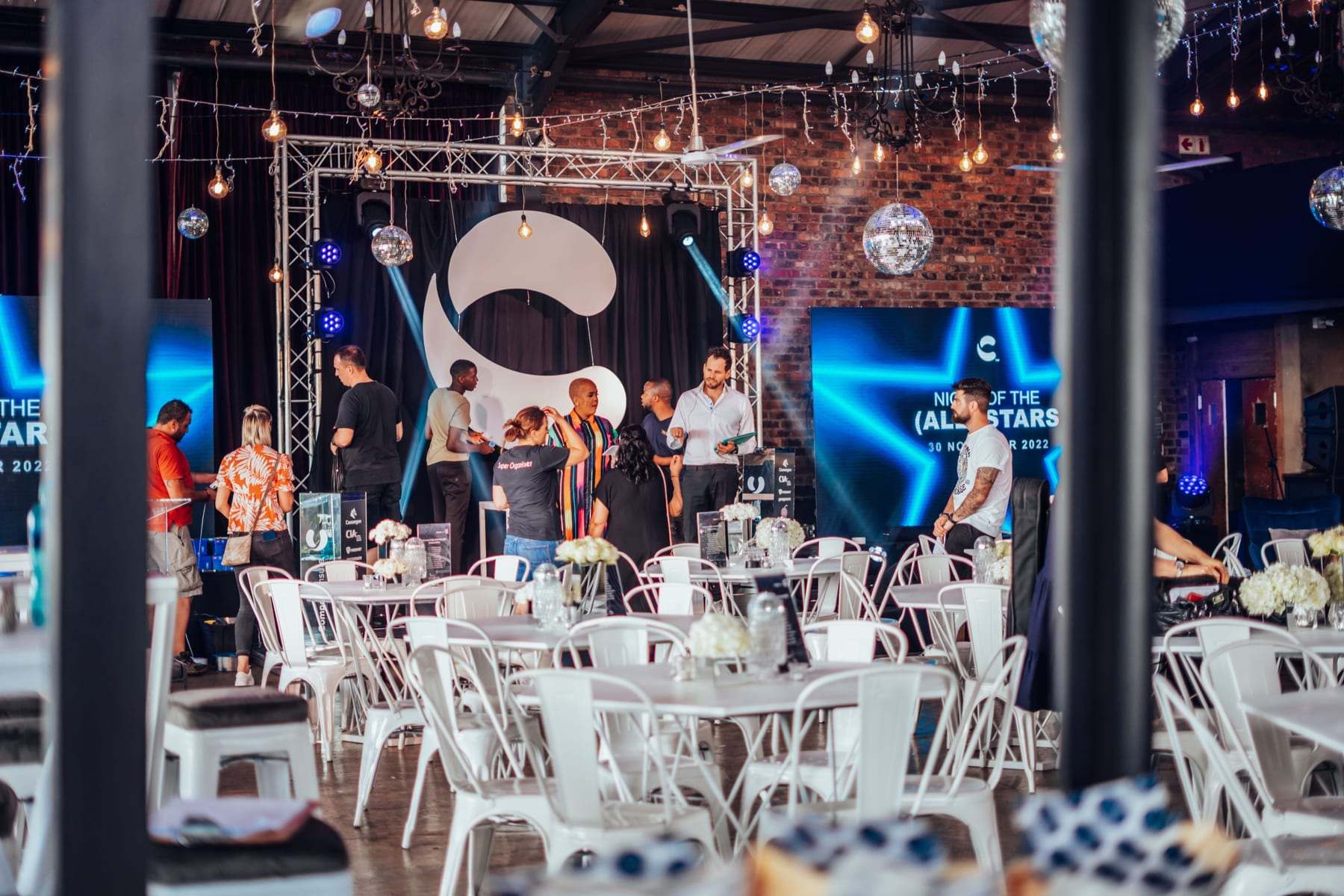 The stage with the Compass logo on a truss frame and LED screens either side