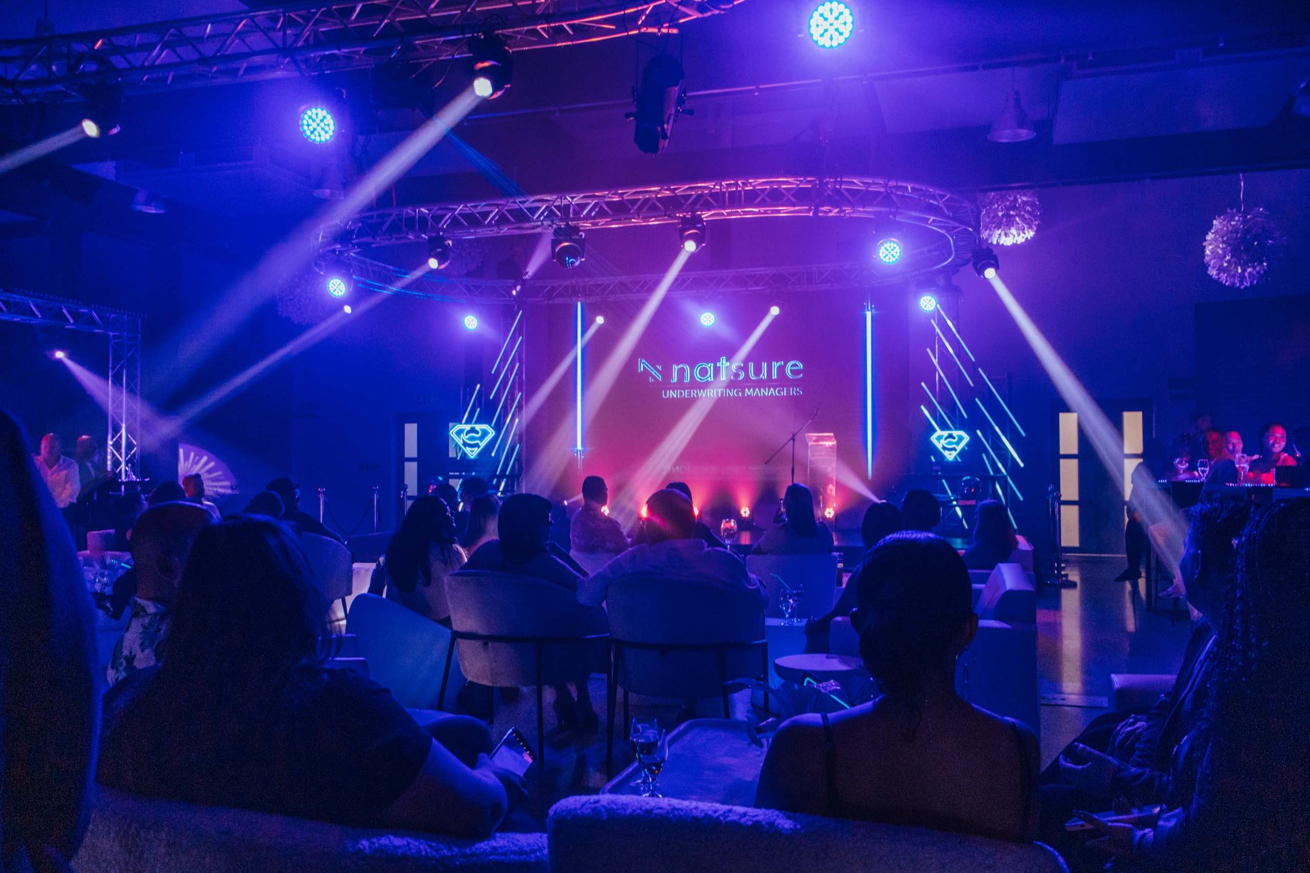 An awards night stage with truss, moving-head beams and a branded backdrop