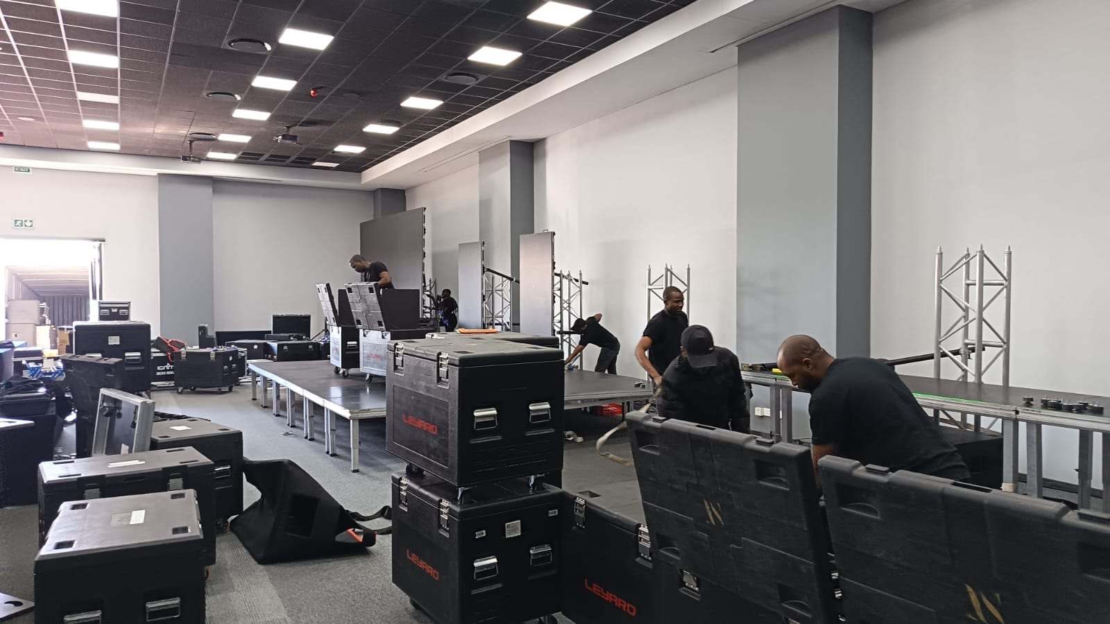 The crew building the stage in an empty hall for BSides 2025