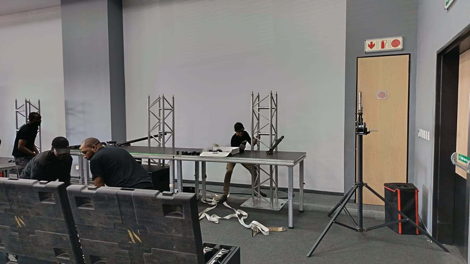 Crew members fitting the stage frame next to the flight cases