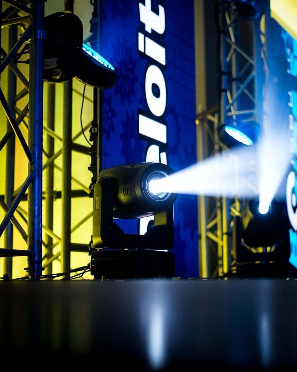 A moving head beside a Deloitte-branded truss tower