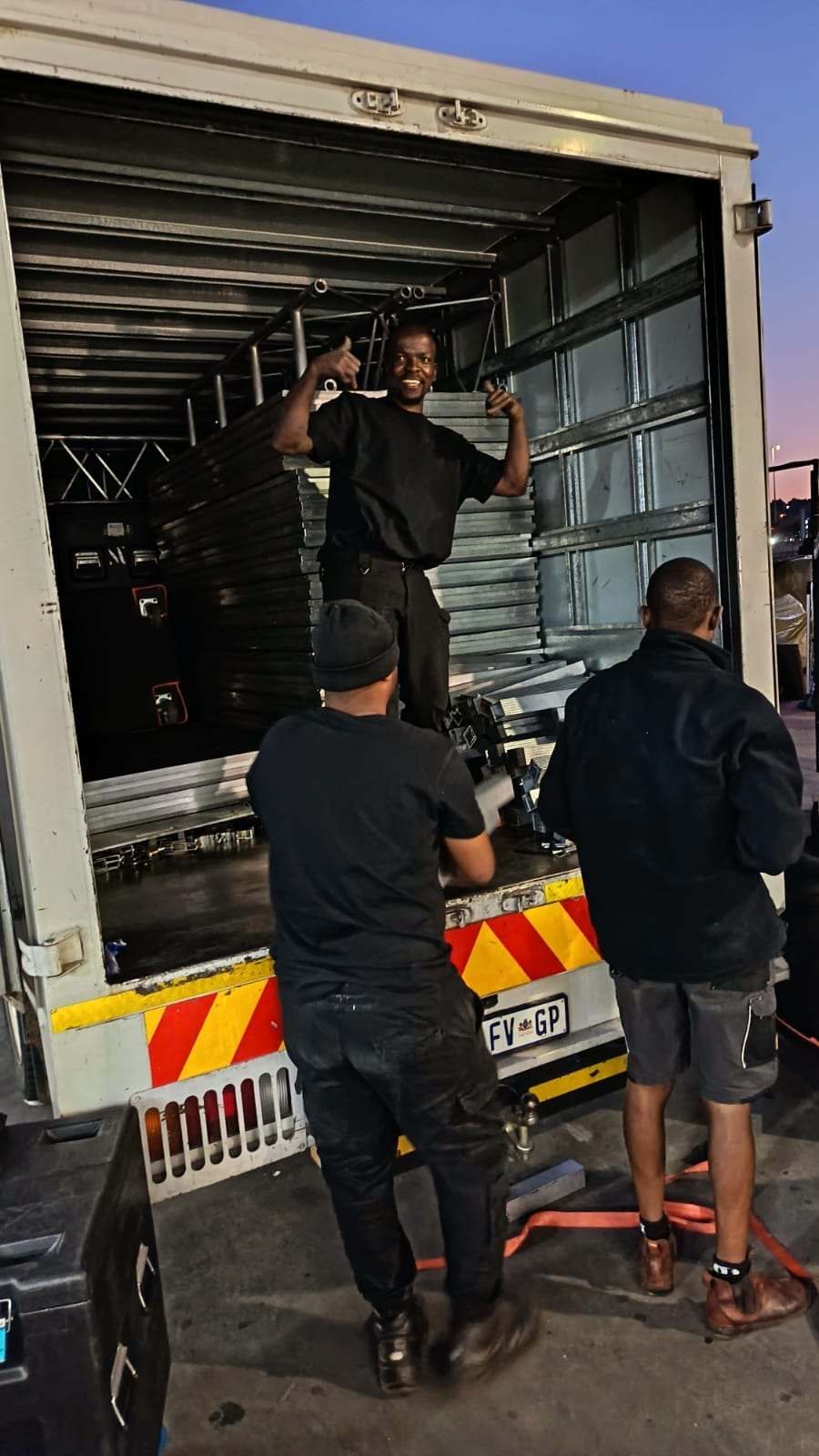 The crew unloading flight cases from the truck