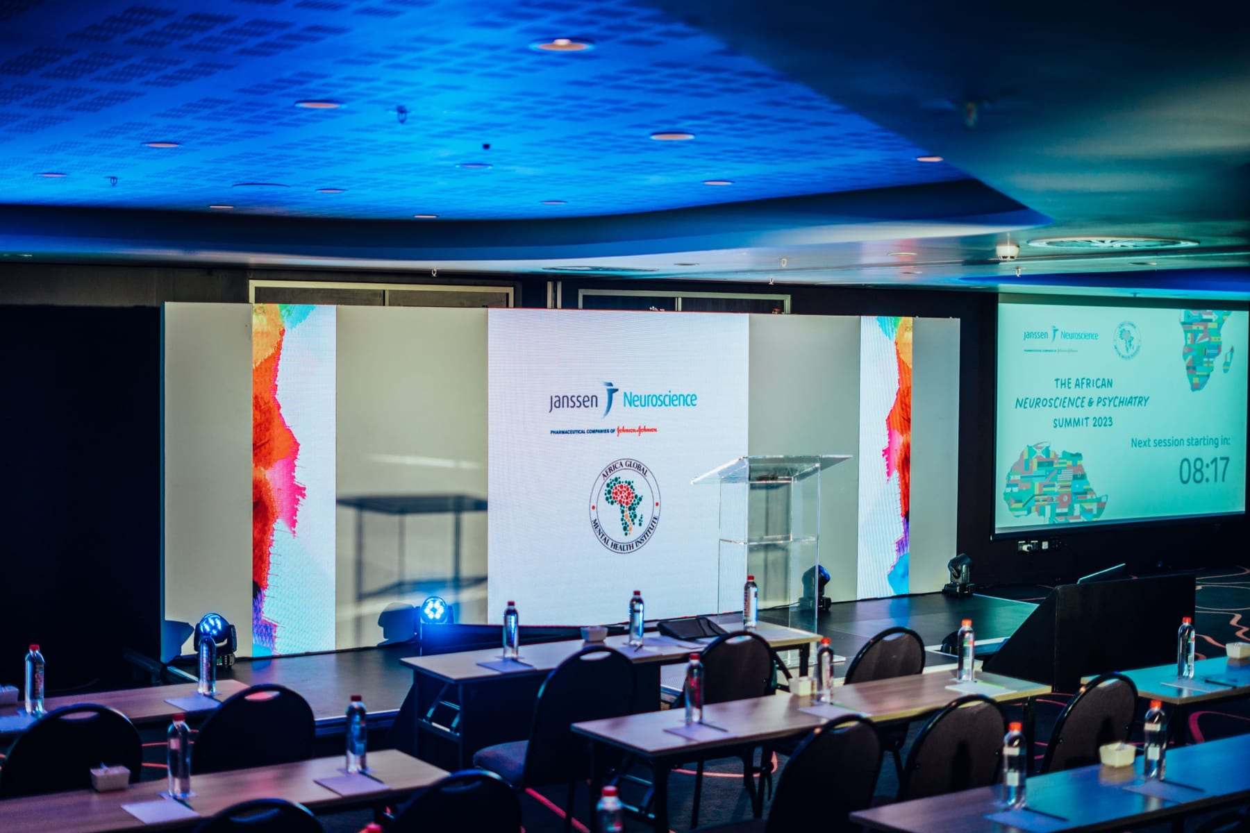 The summit room with three screens across the front and a lectern