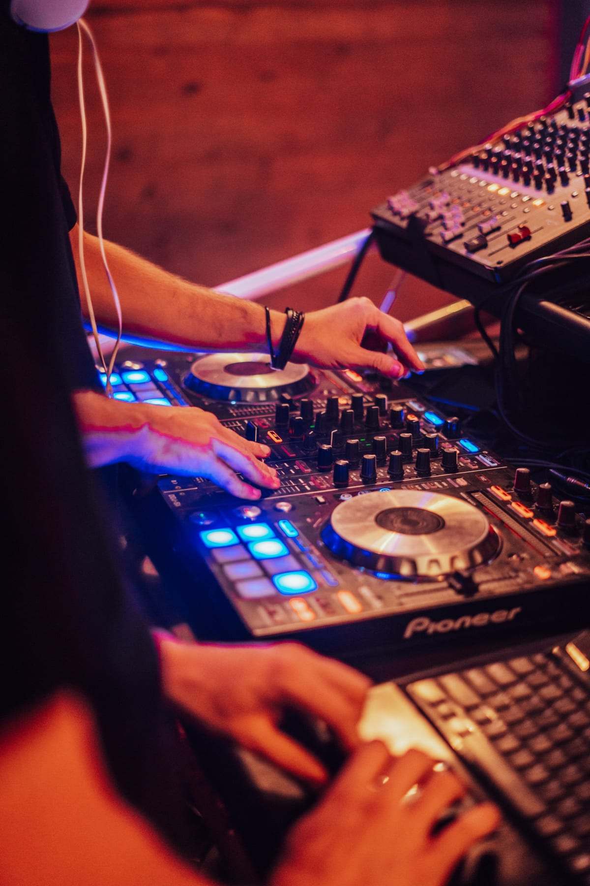 A DJ's hands on a Pioneer controller