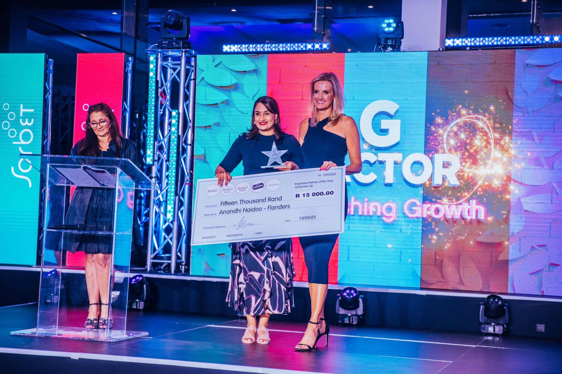 A winner receiving a big cheque on stage at the G Factor awards