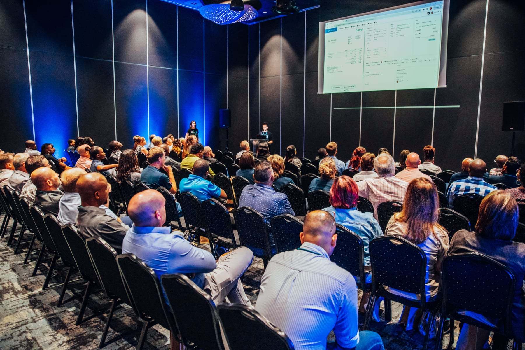 A breakaway room with a projection screen and blue uplighting