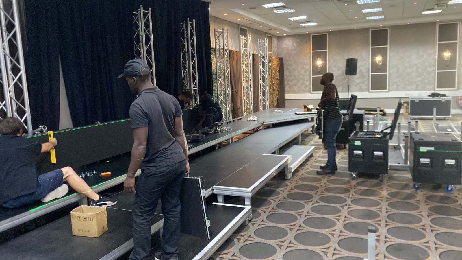 The crew building the stage and truss before a Syspro event