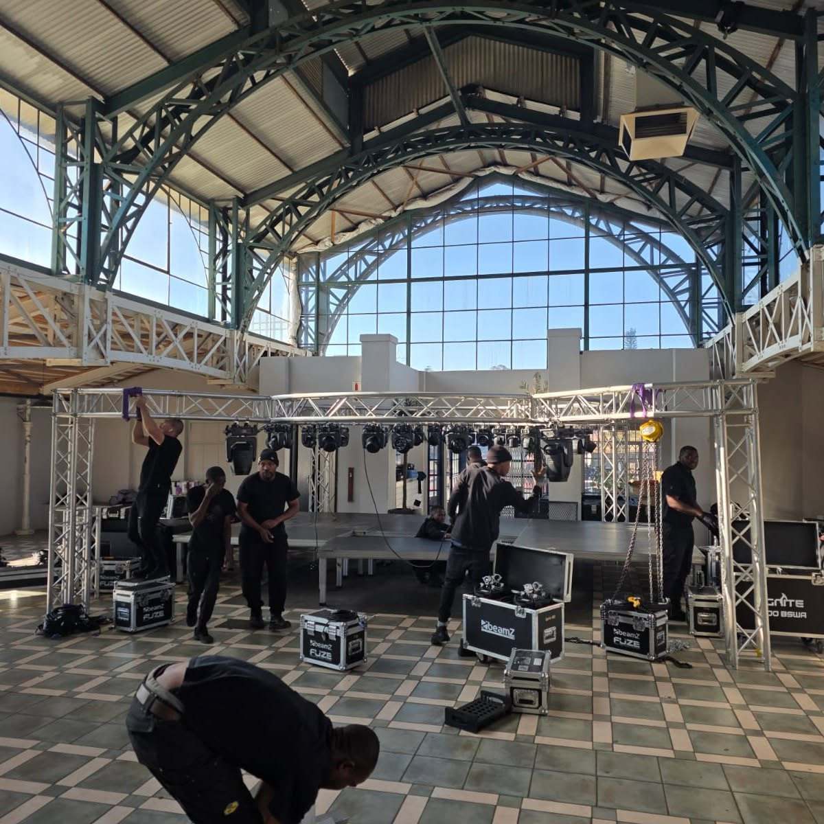 The crew building a stage and truss in a hall