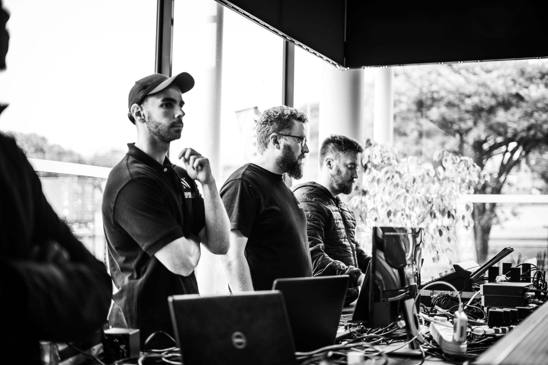 The crew watching the reveal from the desk, in black and white